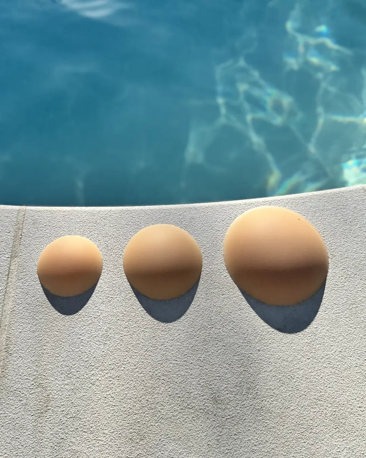 Cache tétons en silicone sans adhésifs, invisibles, disposition en bordure de piscine pour mise en scène estivale.