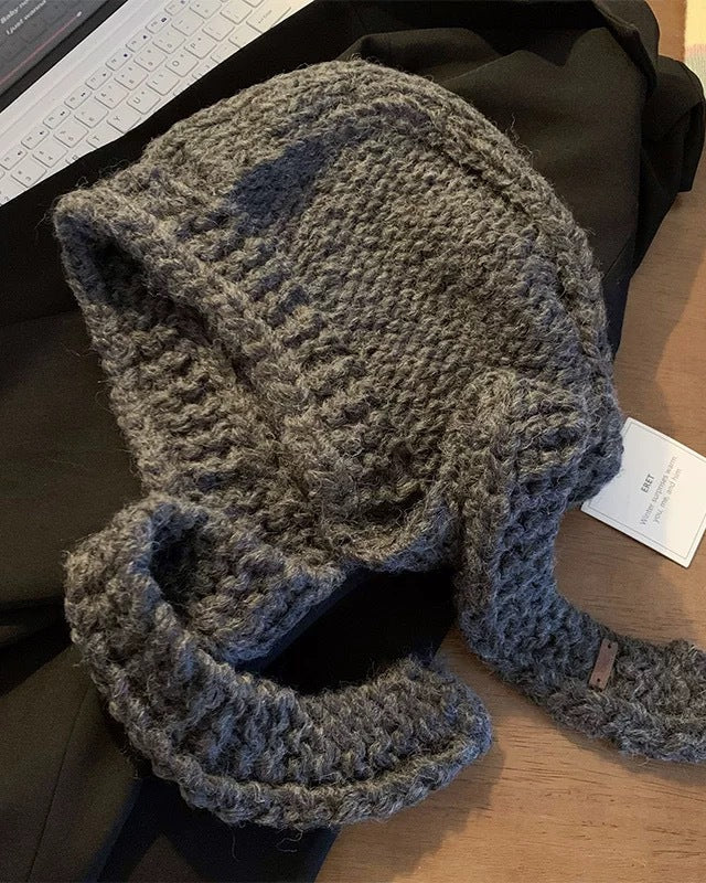 Écharpe cagoule en grosse maille grise sur fond de bureau, idéal pour les nouveautés mode automne-hiver clarisse.