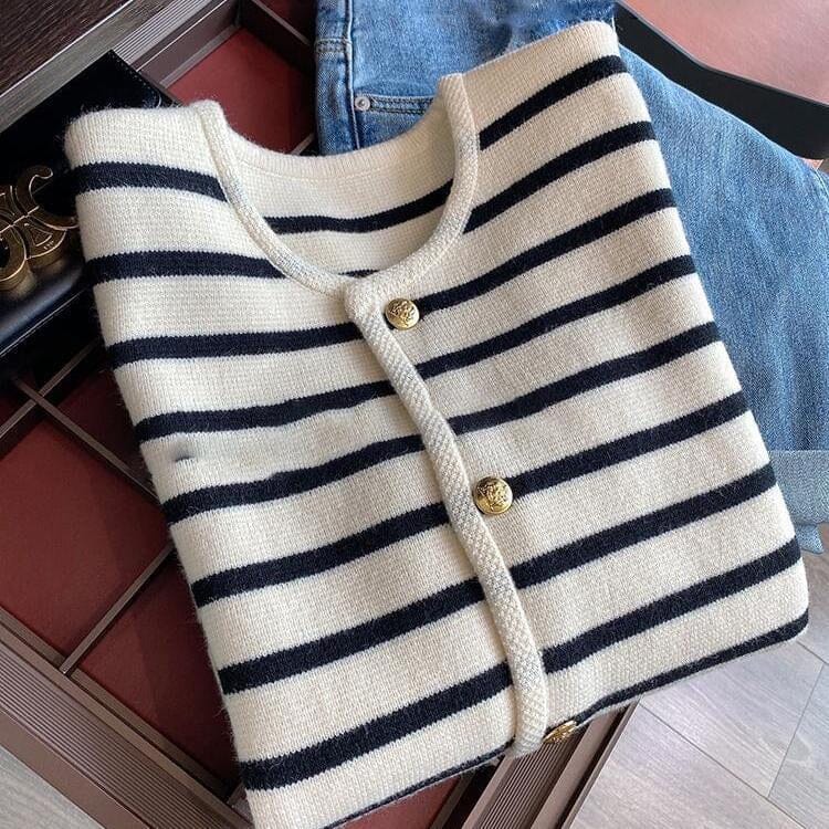 gilet bouton doré tia en laine à rayures marinière bleu et blanc, posé sur un fond, avec des détails en or