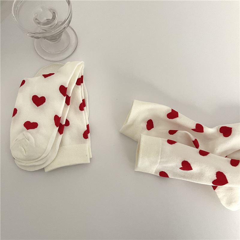 chaussettes en coton blanc avec motifs de coeurs rouges pour femme - modèle valentina, sur une table blanche