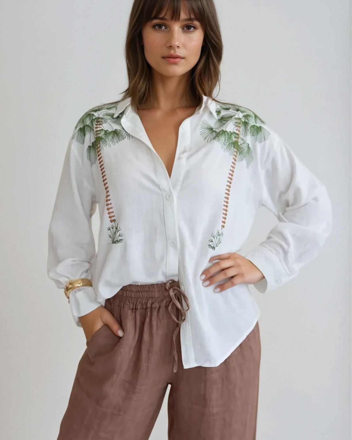 Chemise blanche oversize pour femme avec motifs tropicaux, manches longues et style décontracté pour un look estival.