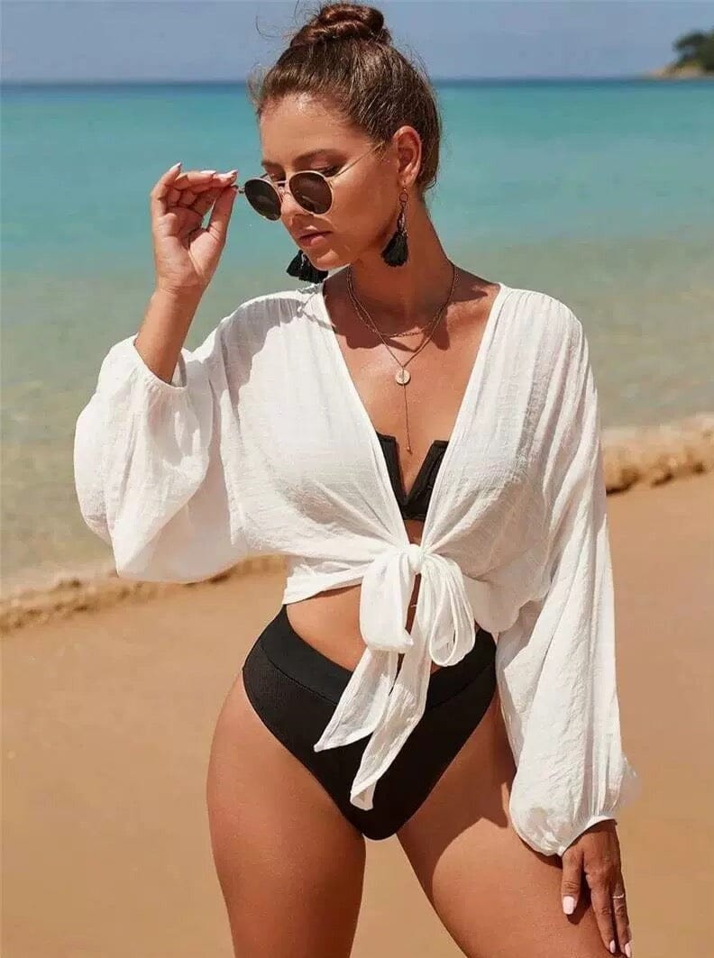 chemise de plage délila en coton blanc portée par une femme à la plage avec bikini noir, parfait pour l'été et les vacances