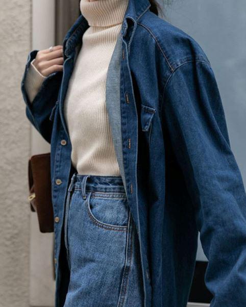 chemise en jean bleue lou portée par une femme avec un col roulé blanc et un sac en bandoulière marron