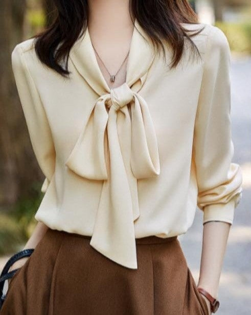 chemise femme en soie beige avec noeud porté par une femme, manches longues, élégante et idéale pour occasions formelles