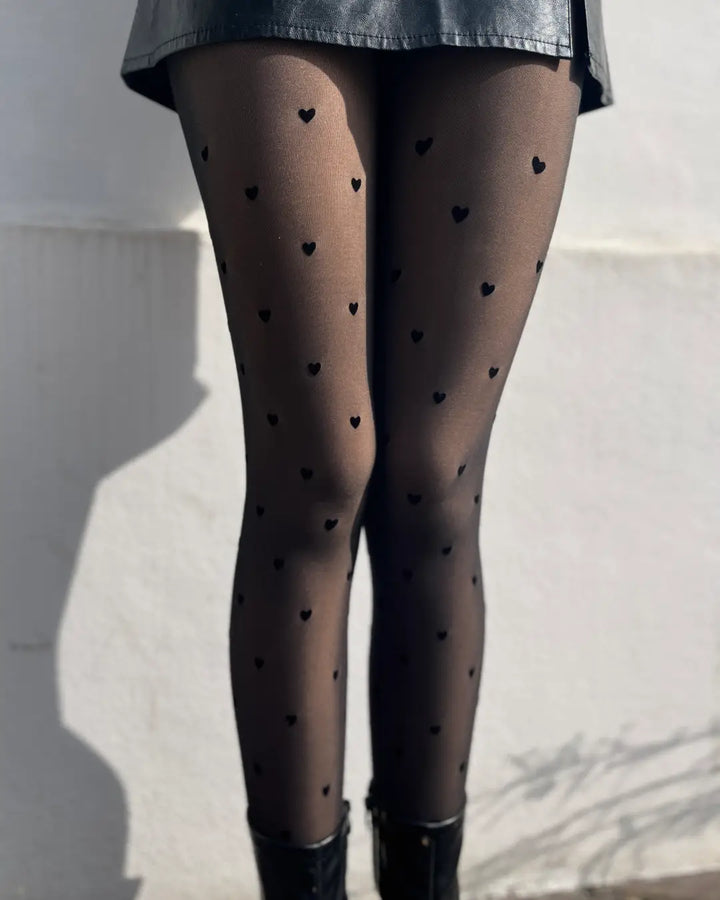 Collant élégant avec motifs de cœurs doublés pour chaleur et style, parfait pour l'hiver sous une jupe.