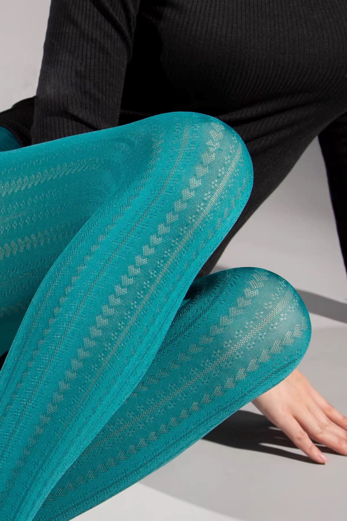 Femme portant des collants fantaisie bleu turquoise avec motif unique, parfaits pour un look élégant et original.