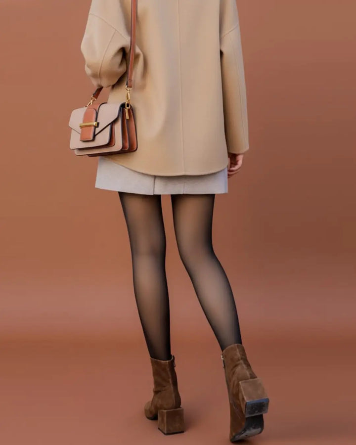 Femme en manteau beige portant un collant polaire transparent et des bottes marron avec un sac en cuir assorti.