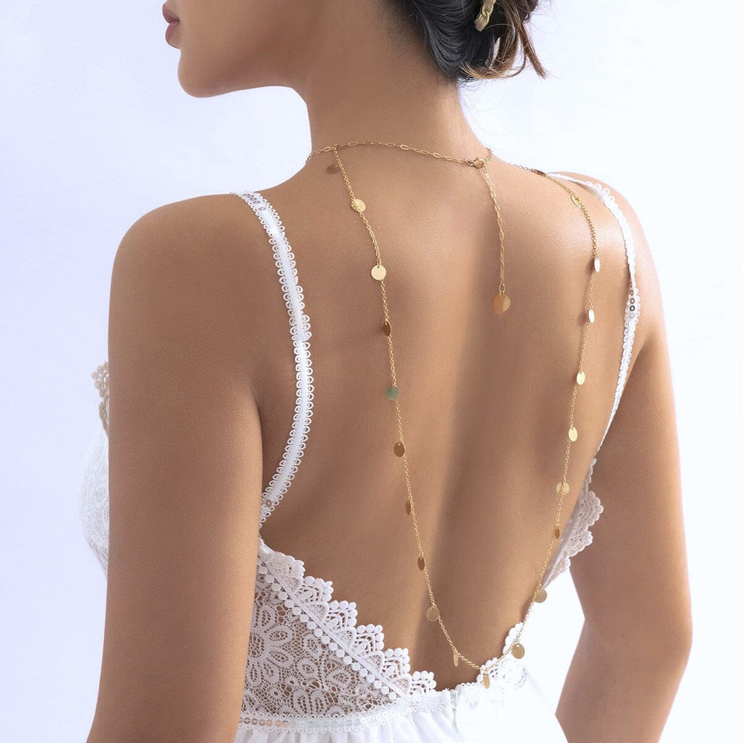 collier de dos alya en or porté par une femme sur une robe dos nu blanche avec dentelle, bijou élégant et délicat