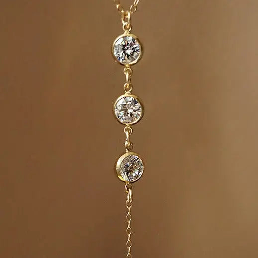 Collier de dos en or, avec trois pendentifs en diamant étincelants, parfait pour une élégance discrète et raffinée.