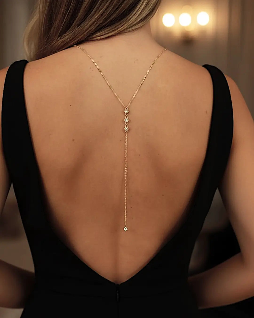 Collier de dos élégant accentué de diamants brillants sur une robe noire décolletée pour un look chic et raffiné.