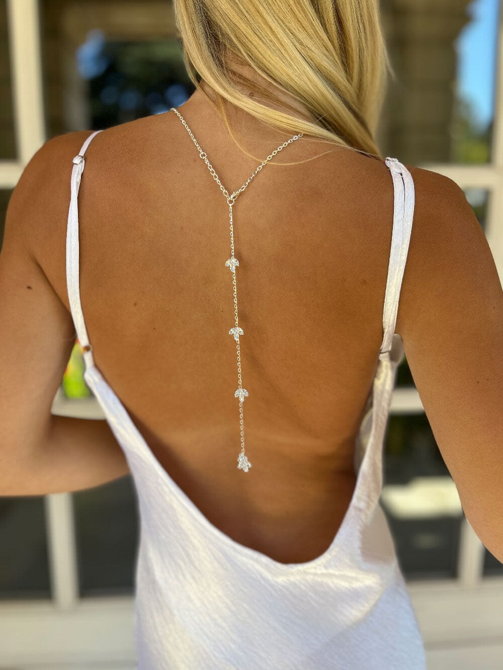 Collier de dos élégant pour mariée, parfait pour un mariage chic, mettant en valeur la robe et le dos dénudé.