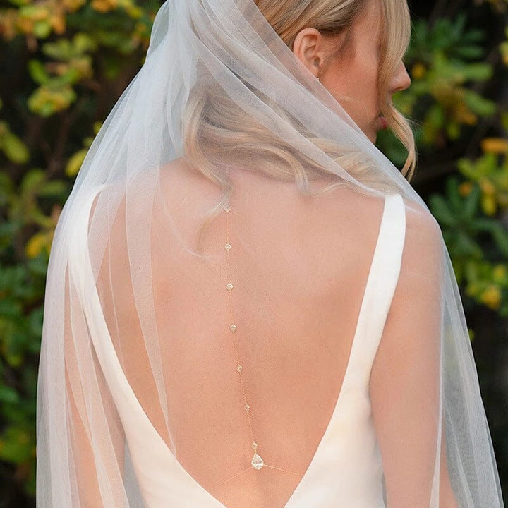 collier de dos pour mariée justine en or délicat avec perles, orné d'un pendentif, porté avec une robe de mariage dos nu
