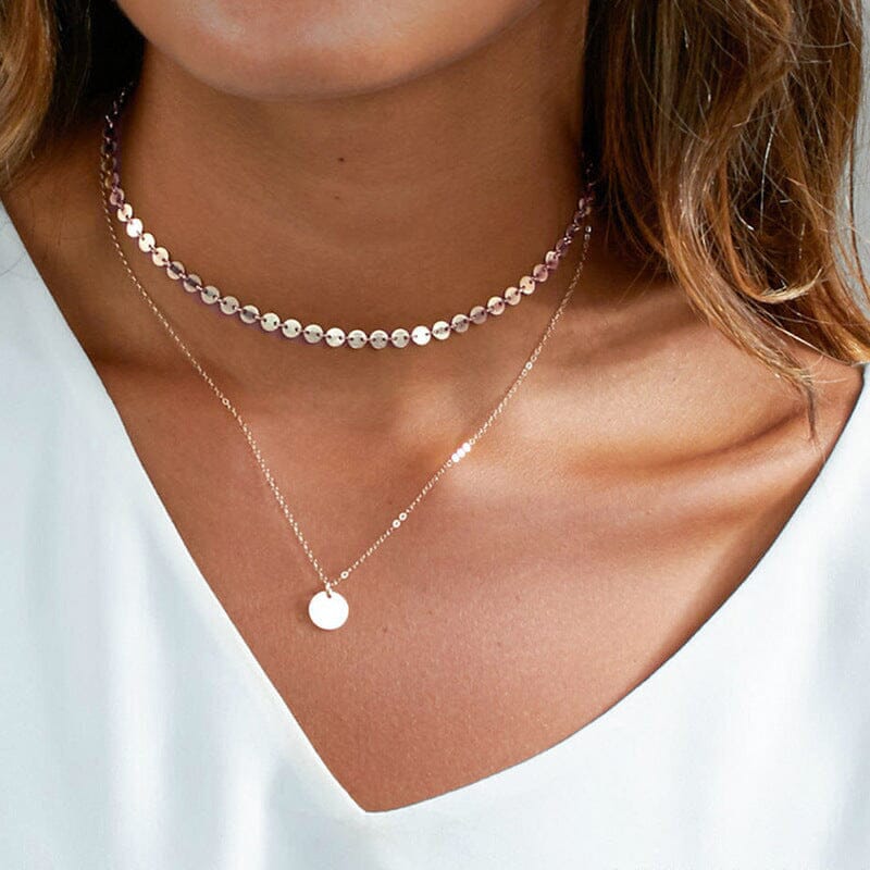 collier multirang doré laya style tendance pour femme superposé avec pendentif circulaire et effet brillant sur peau bronzée