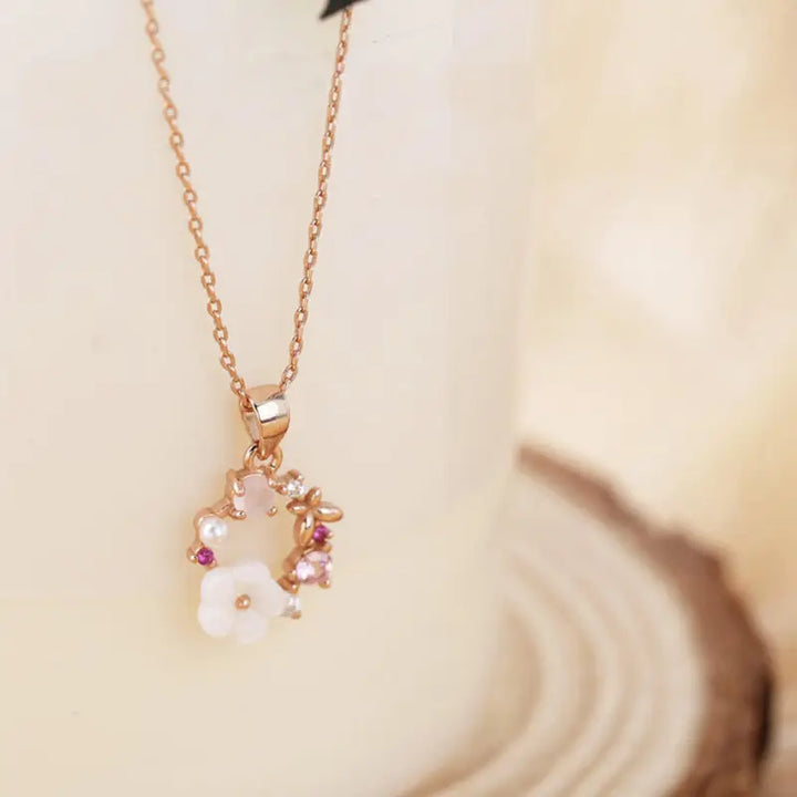 détails d'un collier pendentif rose en forme de couronne de fleurs, design raffiné avec pierres et perles lots