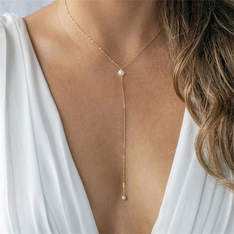 collier perle blanche caroline, sautoir élégant avec chaîne dorée et perle blanche porté avec une robe blanche