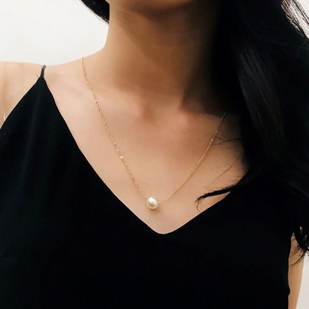 collier de dos anastasia avec une perle en pendentif porté par une femme, idéal pour les tenues élégantes et chic