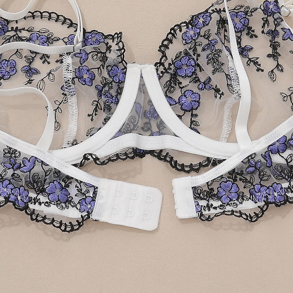 soutien-gorge en dentelle noire avec des fleurs violettes et des attaches blanches, partie d'un ensemble lingerie emelia