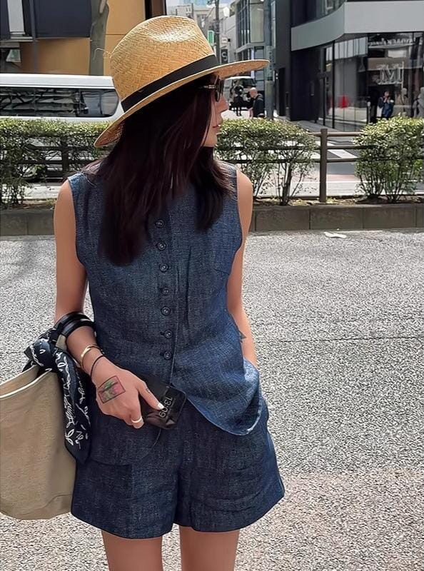 femme portant un ensemble short tee-shirt en jean, accessoirisé avec un chapeau de paille et un sac en toile