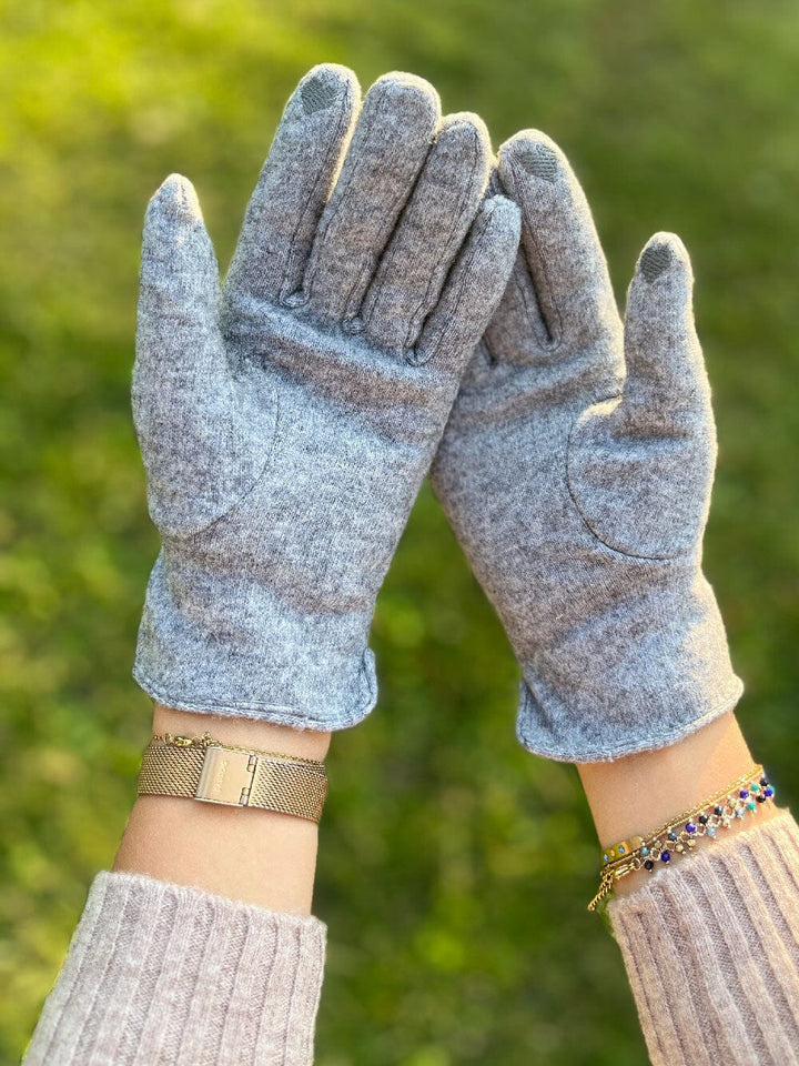 gants tactiles polaire femme léna en laine gris clair avec intérieur douillet, portés par une femme en pull blanc côtelé