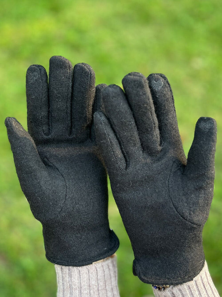 gants tactiles polaire noir pour femme léna posés sur une table avec une tasse de café et un bouton de jean