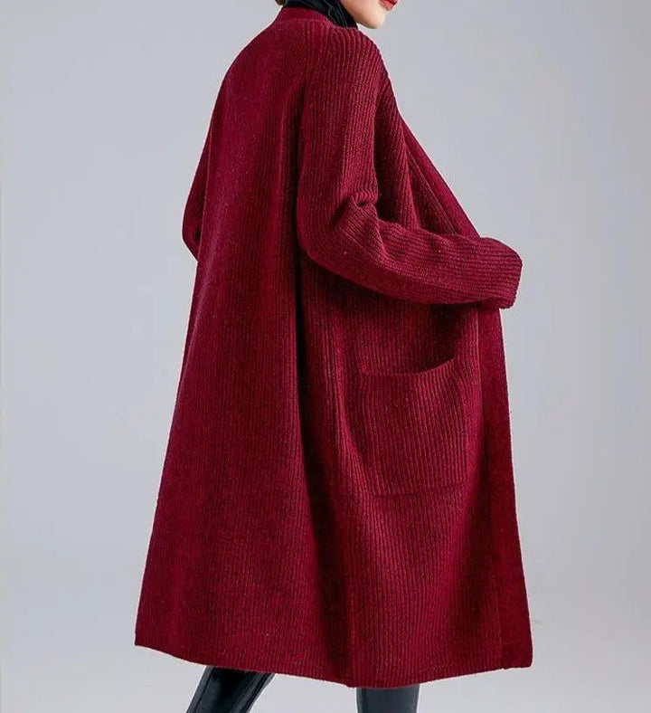 Femme portant un élégant gilet long en laine et cachemire de couleur rouge bordeaux, modèle Lyna.