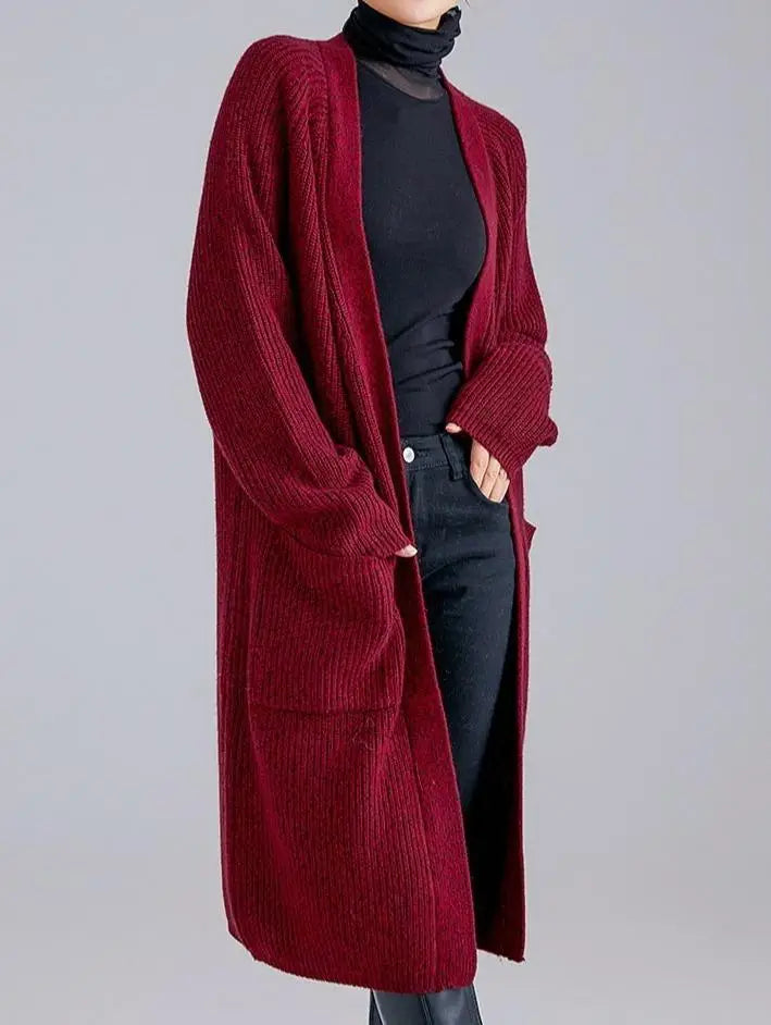 gilet long femme en laine et cachemire couleur bordeaux avec col en V porté par une femme avec un pull noir et jean