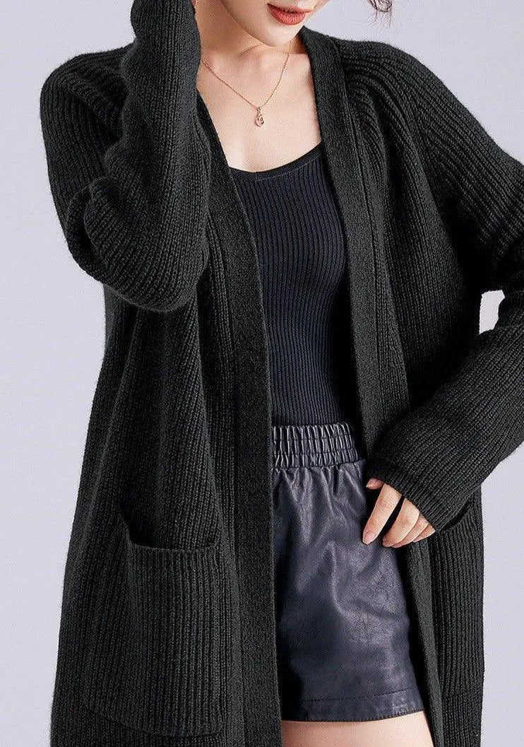 Gilet long pour femme en laine et cachemire de couleur noire, porté par un mannequin avec un haut noir et un short.