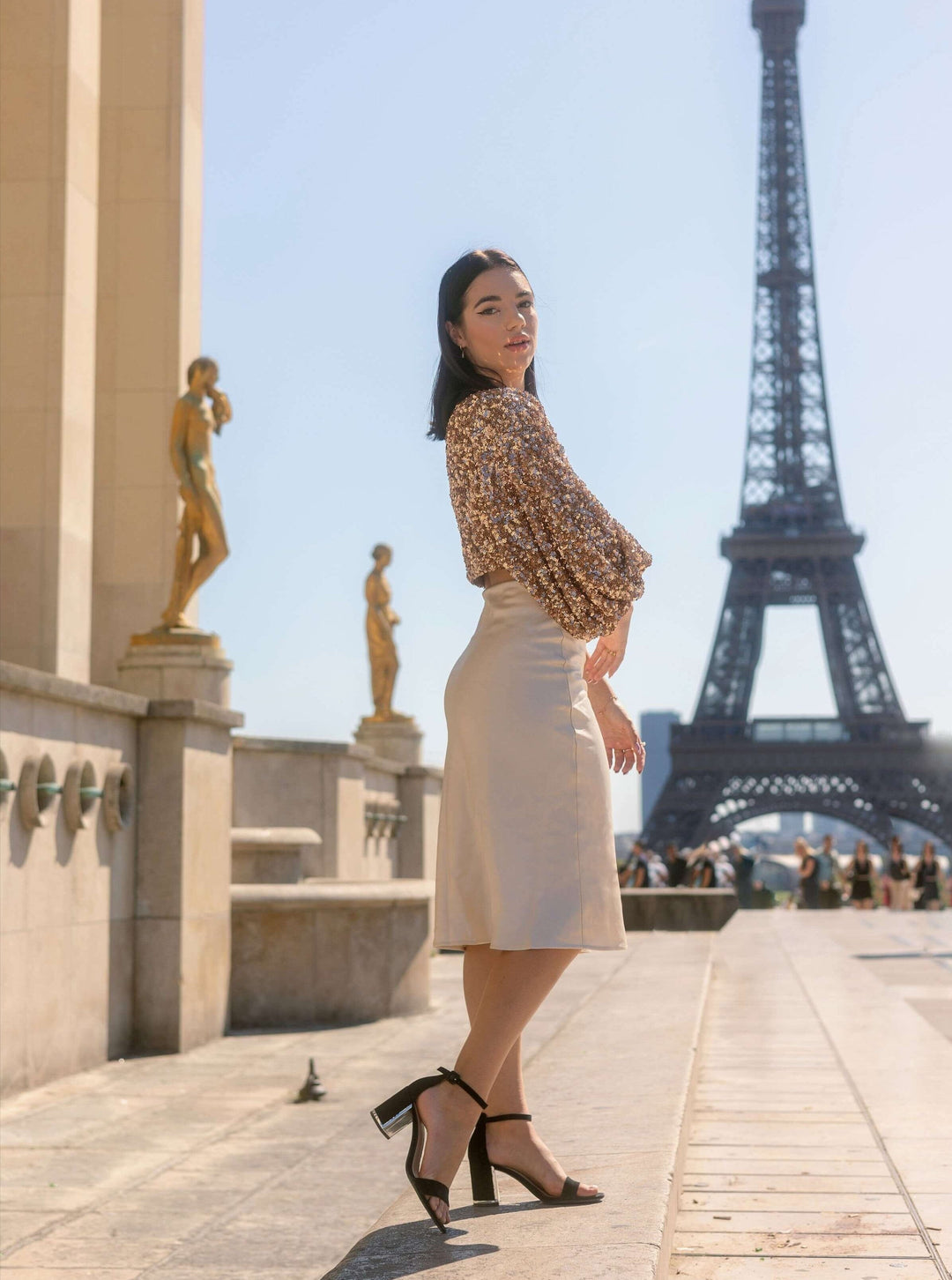 Jupe longue satin Eléonore élégante portée à Paris avec vue sur la tour Eiffel, parfaite pour un look sophistiqué.