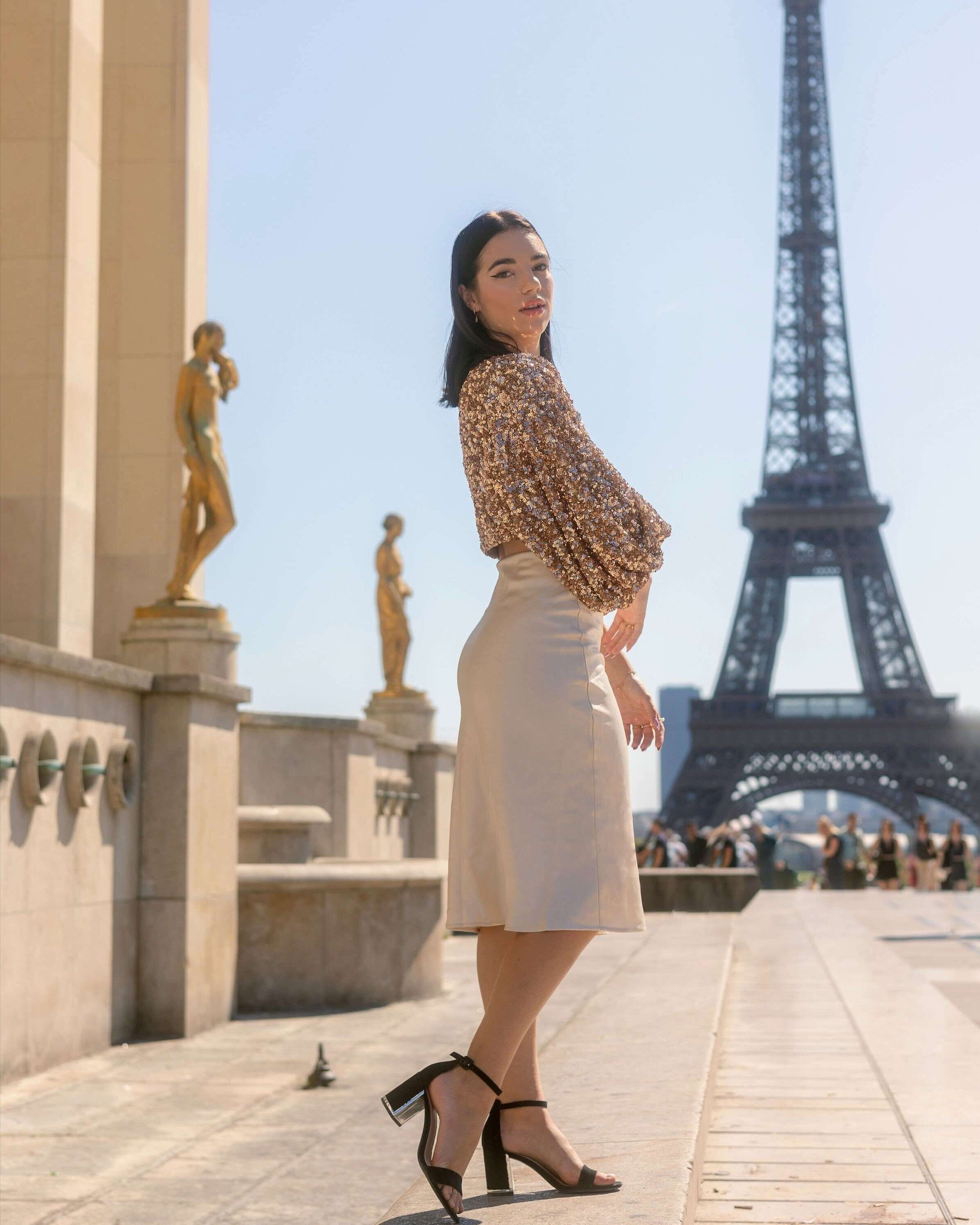 Jupe longue satin Eléonore élégante portée à Paris avec vue sur la tour Eiffel, parfaite pour un look sophistiqué.