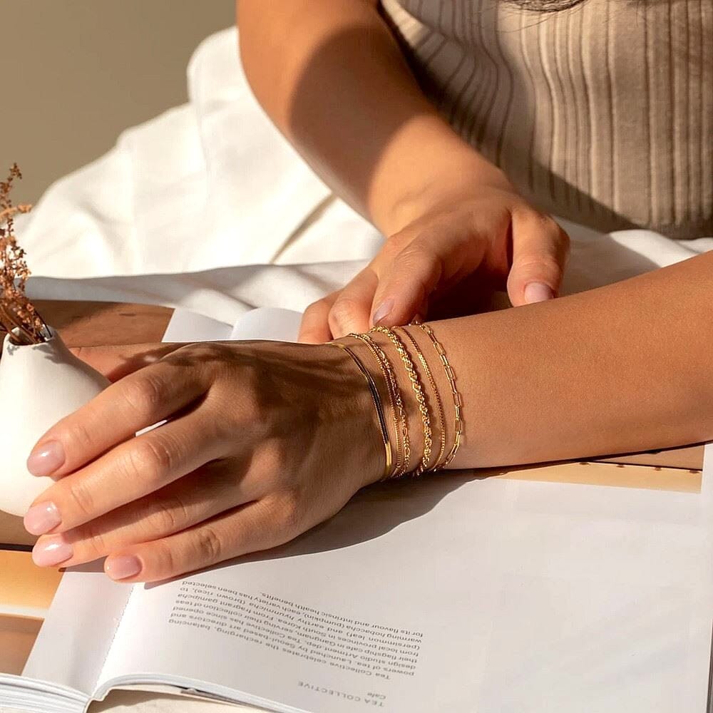 lot de bracelets martine pour femme en or élégant et sophistiqué, posés sur un poignet avec une robe beige