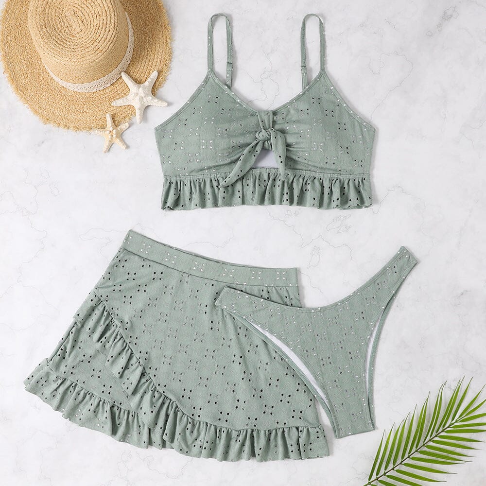 maillot de bain jupe barbara deux pièces vert à volants avec chapeau de paille et décorations tropicales sur fond blanc