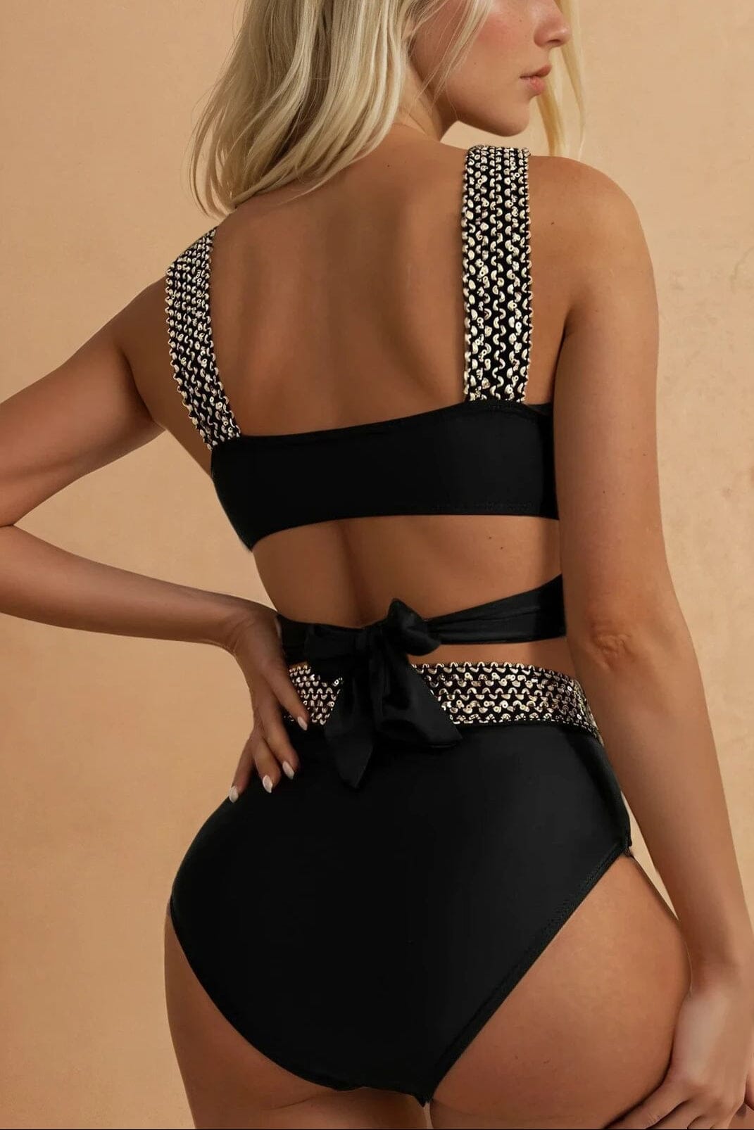 Femme portant un maillot de bain 2 pièces noir taille haute à sequins, vue de dos, modèle "nadia", mode estivale.