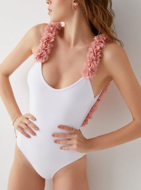 maillot de bain une pièce blanc avec bretelles fleuries roses porté par une femme, design élégant et féminin pour l'été