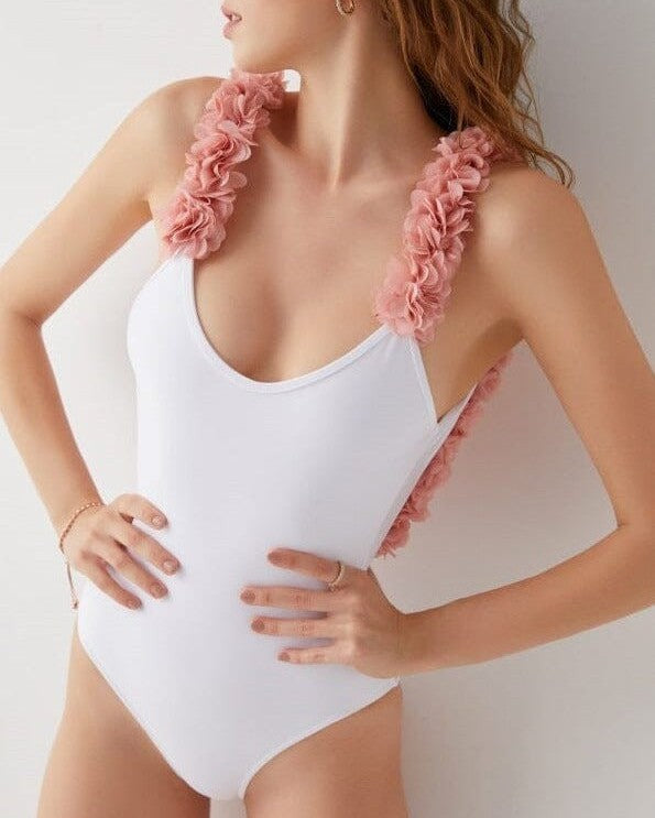 maillot de bain une pièce blanc avec bretelles fleuries roses porté par une femme, design élégant et féminin pour l'été