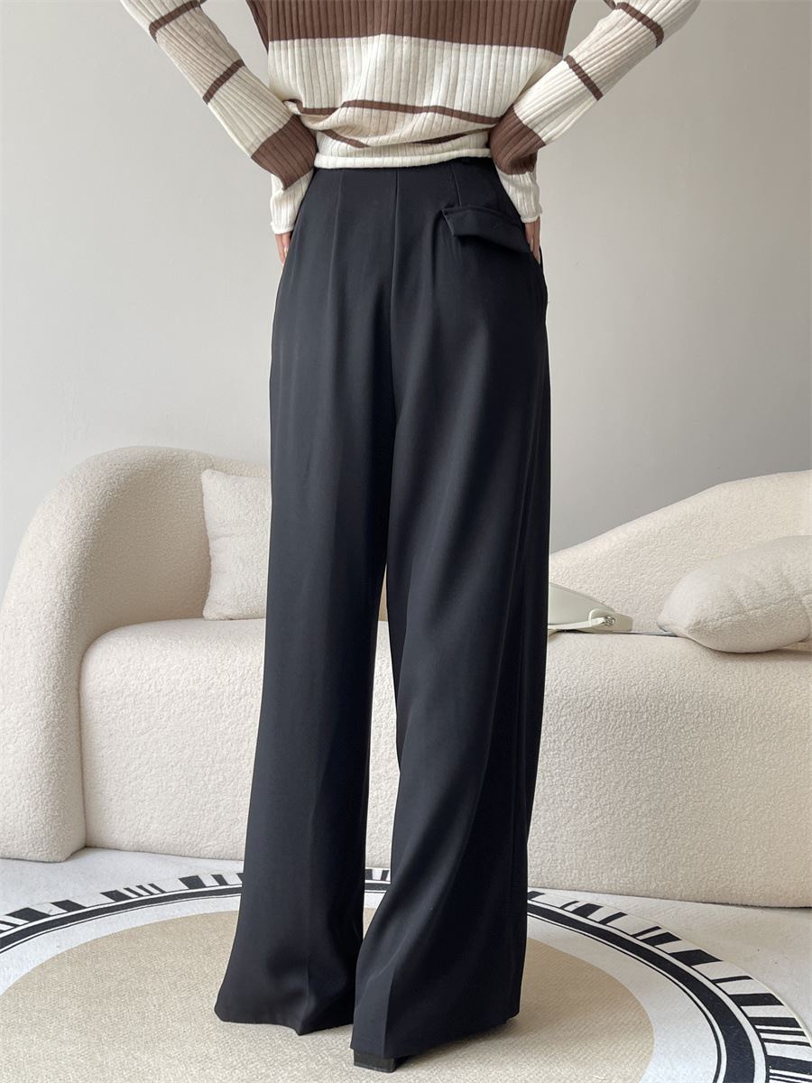 Pantalon ample fluide noir pour femme, élégant et confortable, porté avec un haut rayé beige et marron, idéal pour tous les jours