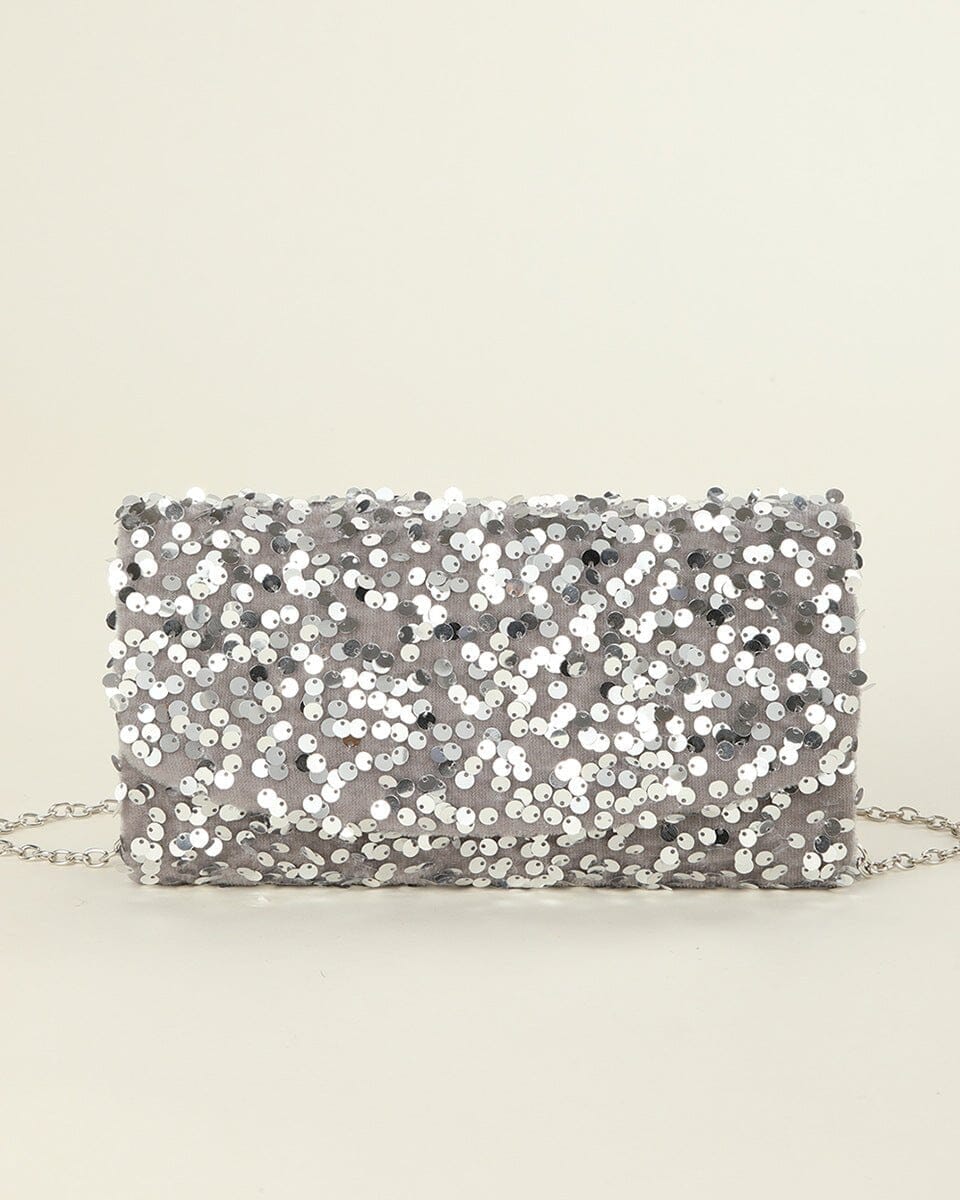 Pochette de soirée élégante en sequins argentés avec chaîne fine, parfaite pour rehausser une tenue de fête.