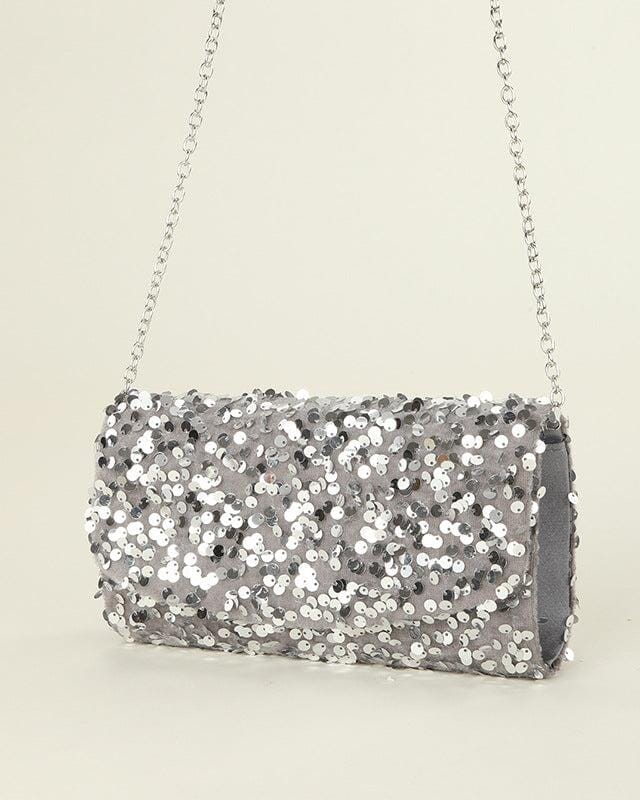 Pochette de soirée à sequins argentés avec chaîne, parfaite pour compléter une tenue élégante et festive.