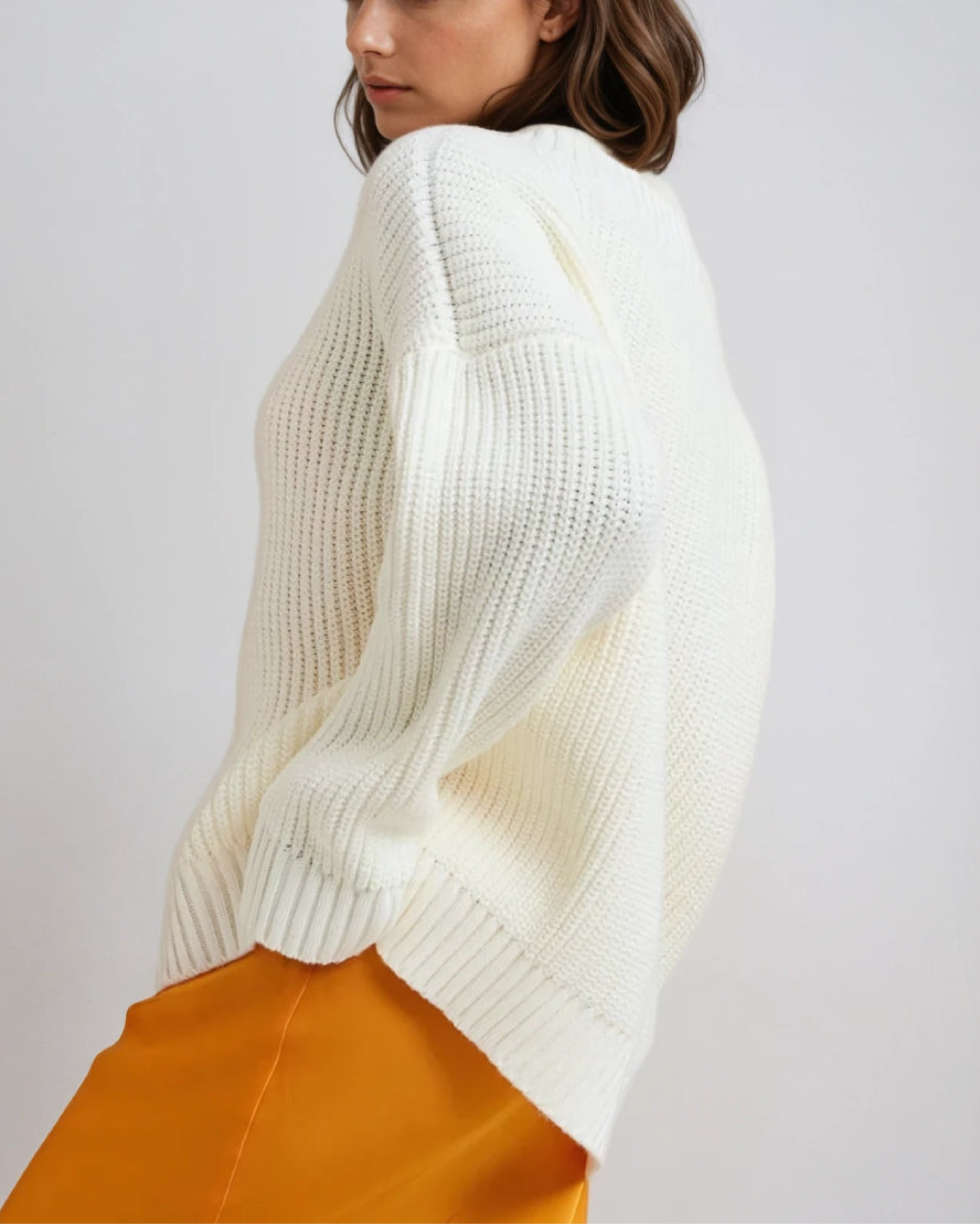 Modèle portant un pull col V manches longues blanc en maille, style décontracté et élégant, vu de côté.