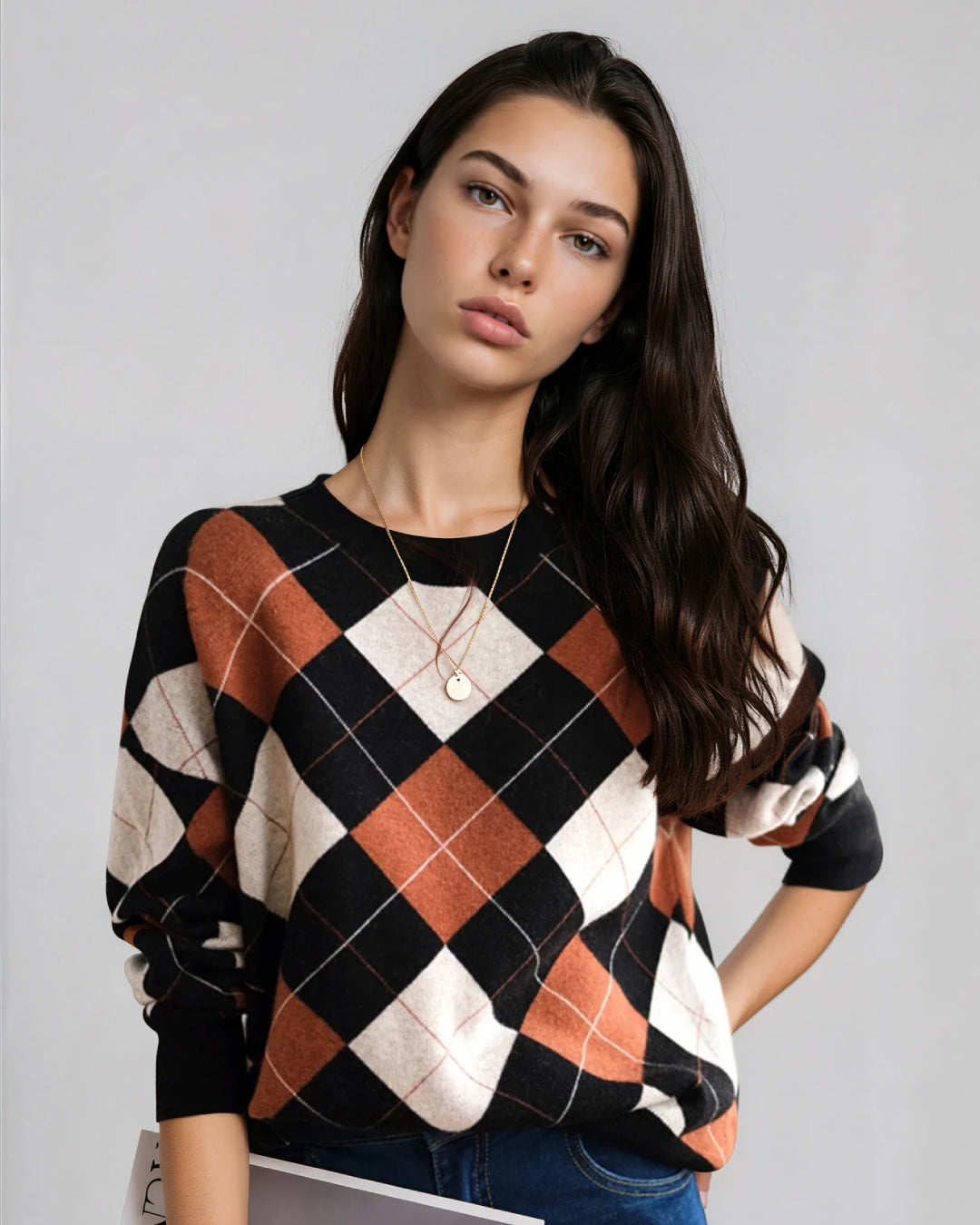 femme portant un pull à carreaux vintage noir et orange, tenant un magazine, idéal pour un look automnal décontracté