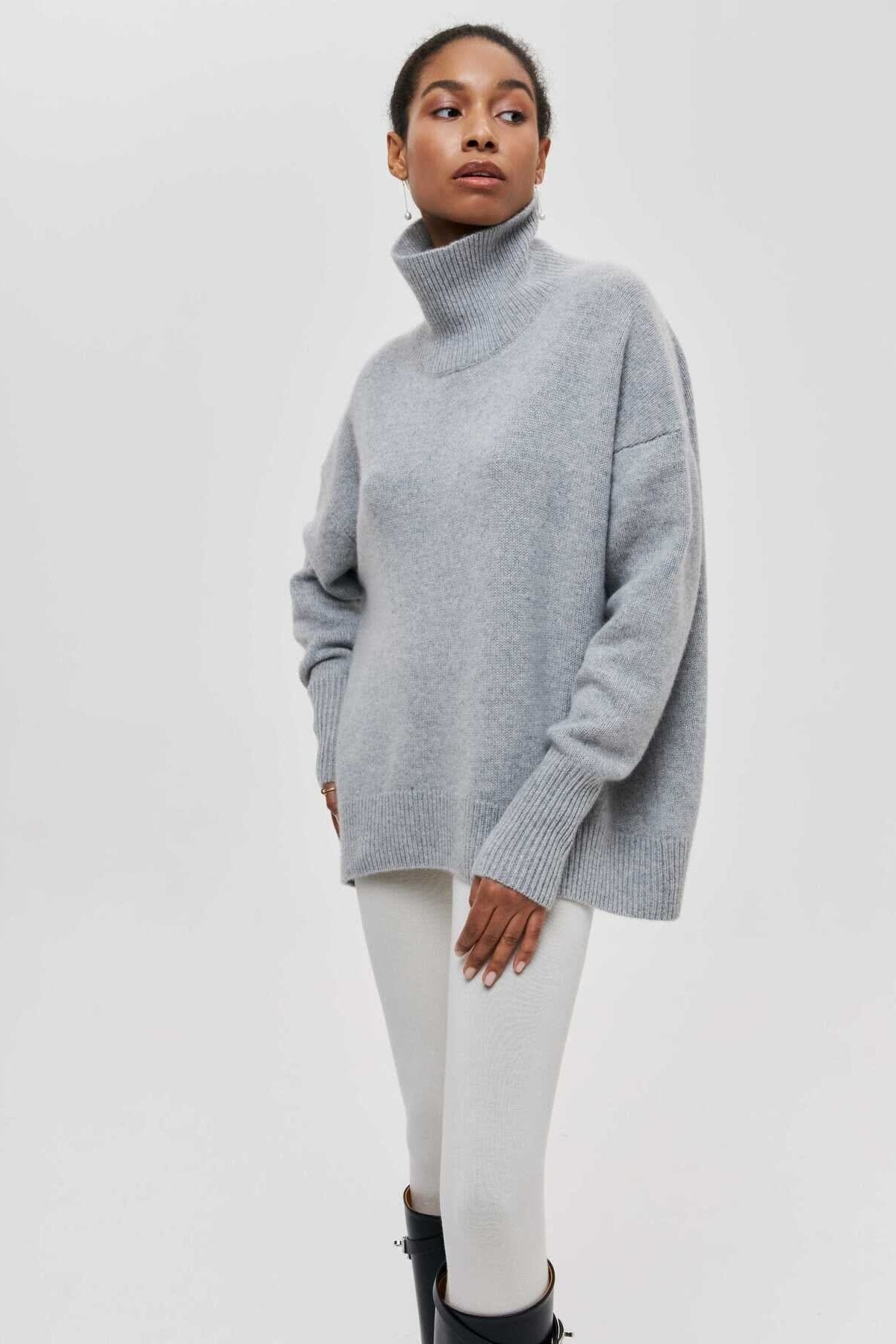 Modèle portant le pull col cheminée Leslie en laine douce gris clair, tendance automne hiver pour femme élégante.