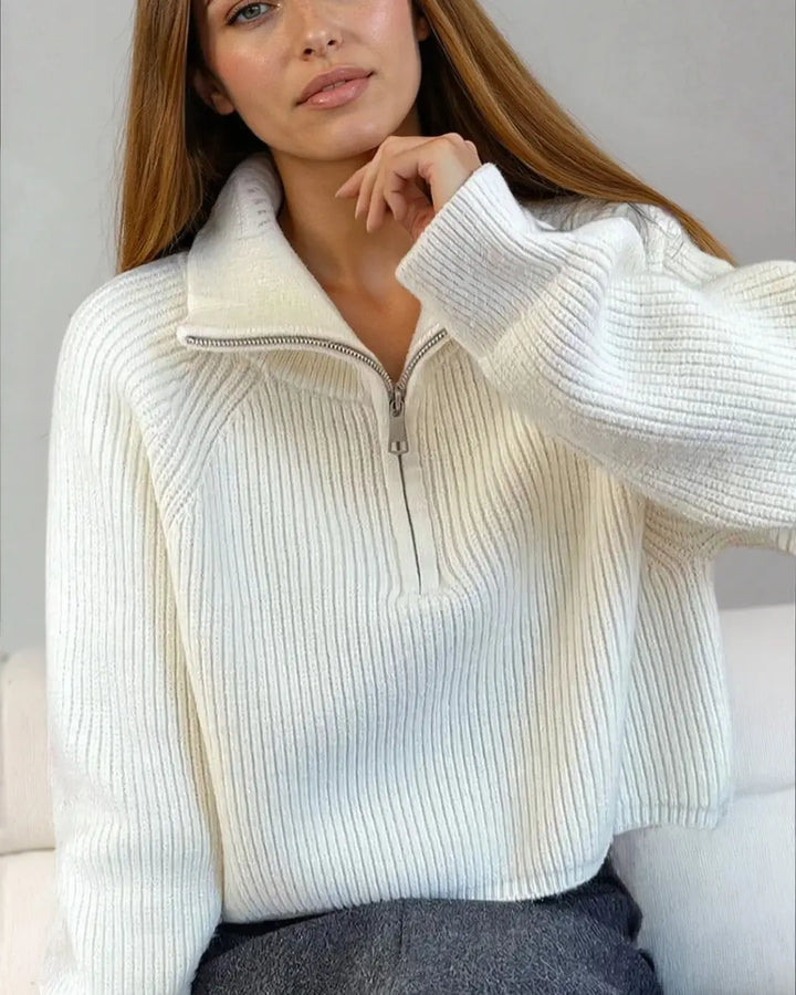 Pull à zip court blanc Indiana porté par une femme, parfait pour un look décontracté et élégant en toute saison.