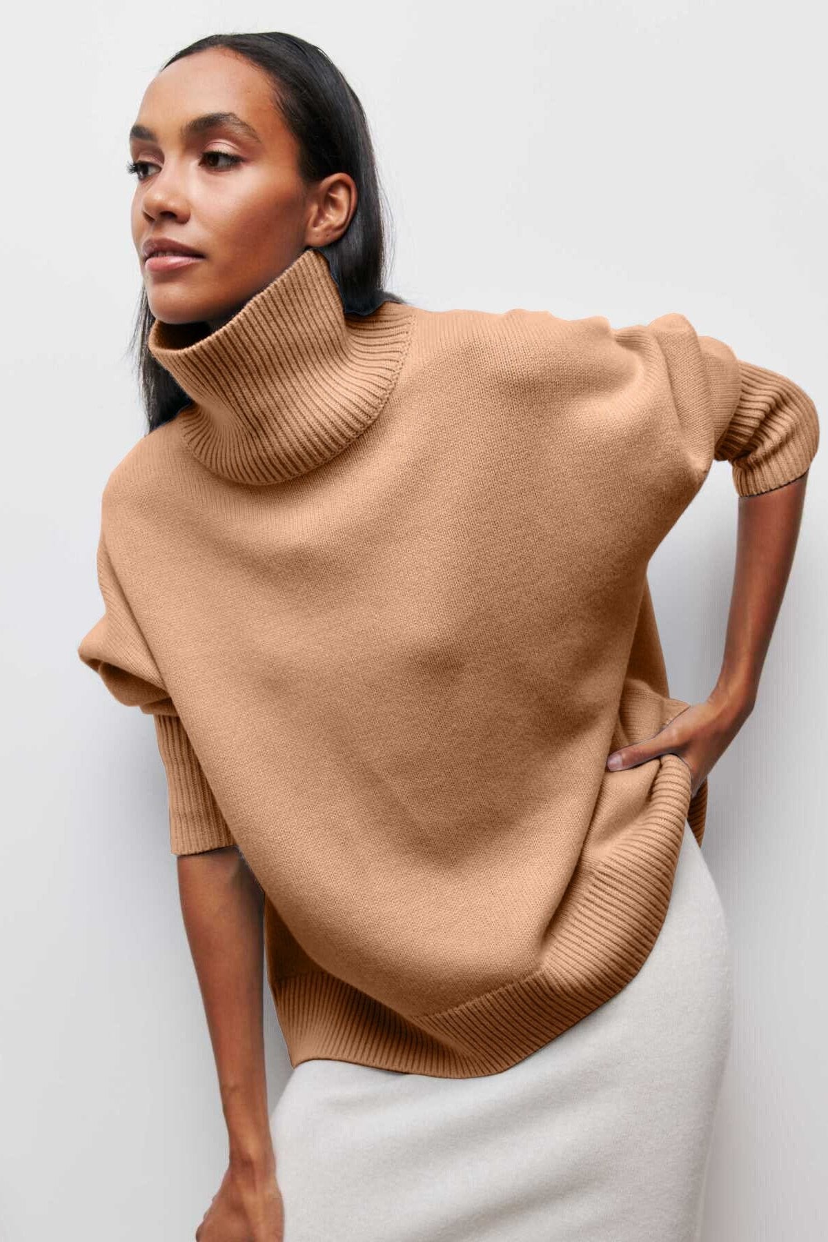 Pull col cheminée en maille beige pour femme moderne, idéal pour un look élégant et confortable en automne.