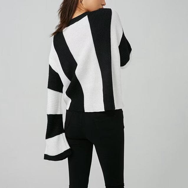 Pull oversize en blanc et noir, manches longues et larges, porté de dos par une femme, style confortable et tendance