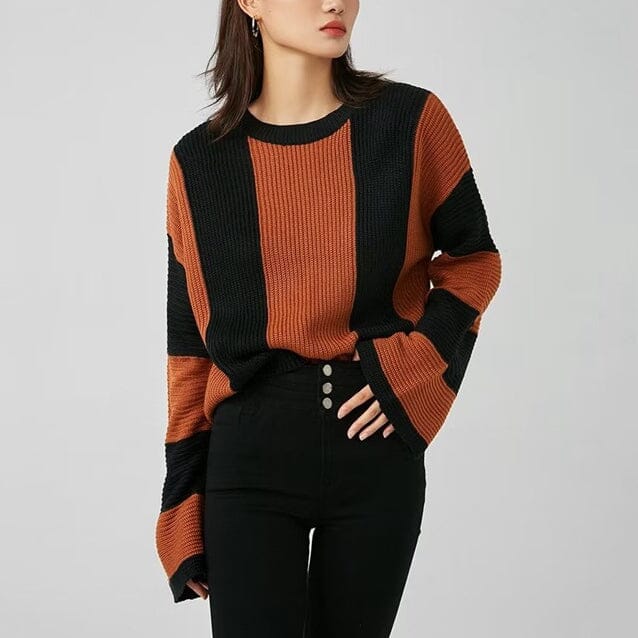 pull oversize à rayures noires et oranges porté par une femme, parfait pour un look décontracté et tendance