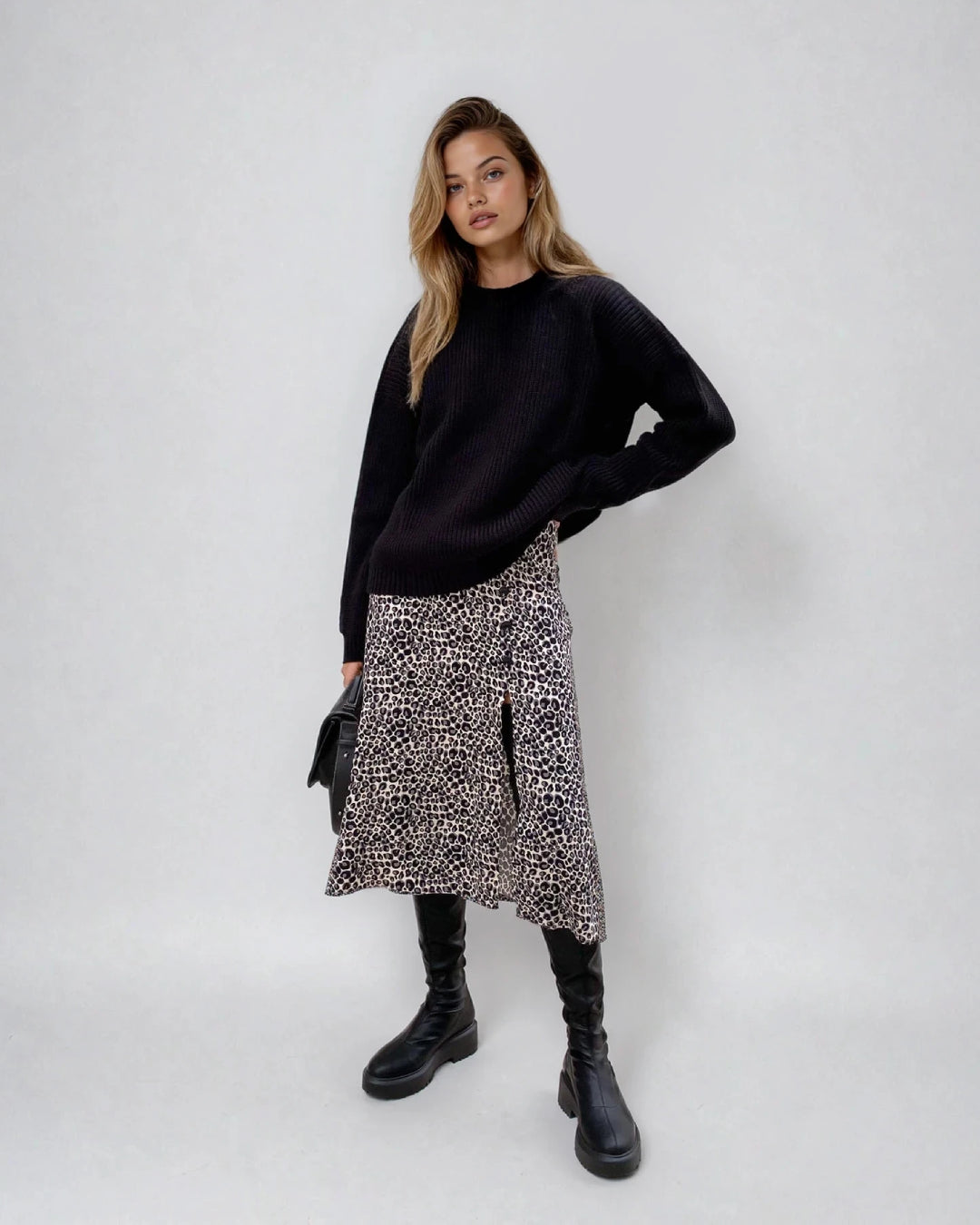 Pull en maille noir ample avec jupe imprimée léopard, manches longues, col rond, style décontracté et tendance.