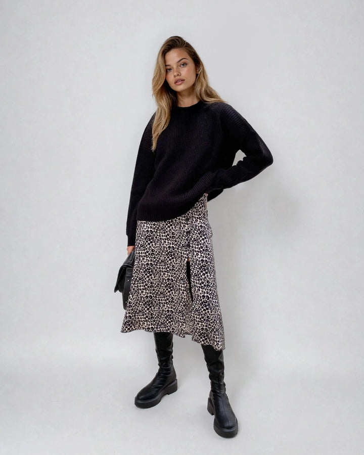 Pull en maille noir ample avec jupe imprimée léopard, manches longues, col rond, style décontracté et tendance.