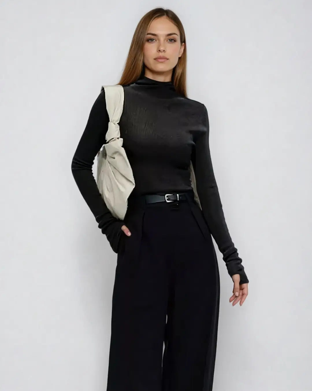 Pull manches longues mitaines élégantes porté par une femme avec un style chic et moderne, sac à l'épaule.