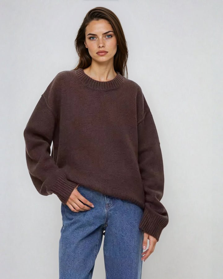 Pull col rond brun avec coutures visibles pour femme, style Natalia, manches longues, porté avec jean bleu décontracté.