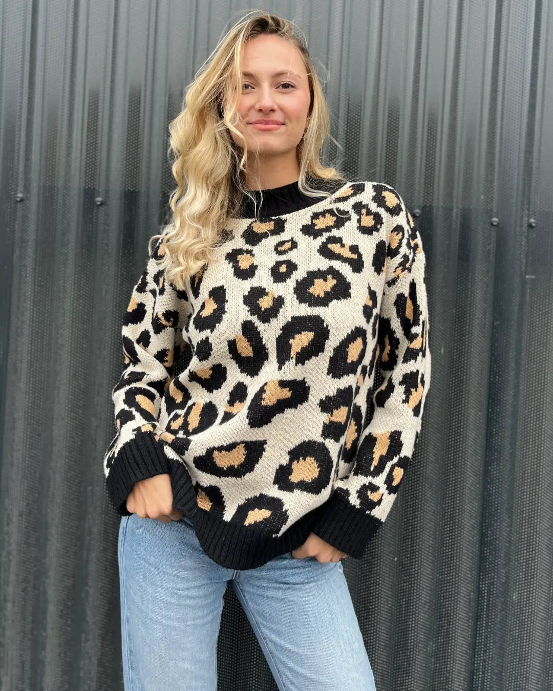 Femme portant un pull léopard à manches longues dans un style décontracté pour l'automne. Confort et tendance assurés.