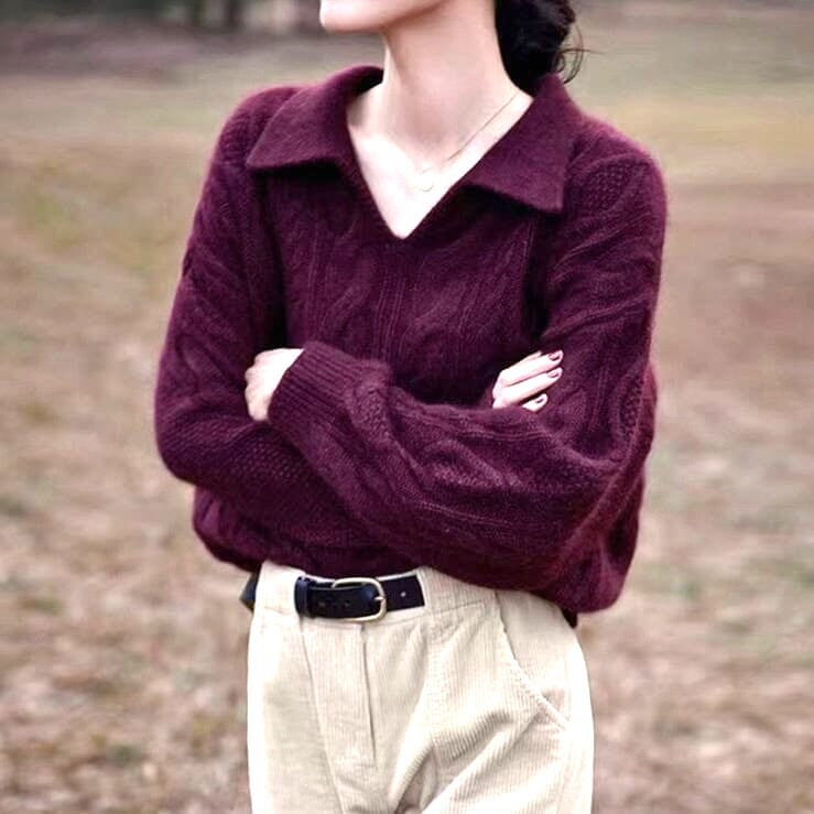 femme portant un pull polo en maille col en v de couleur aubergine, les bras croisés et des pantalons de couleur beige